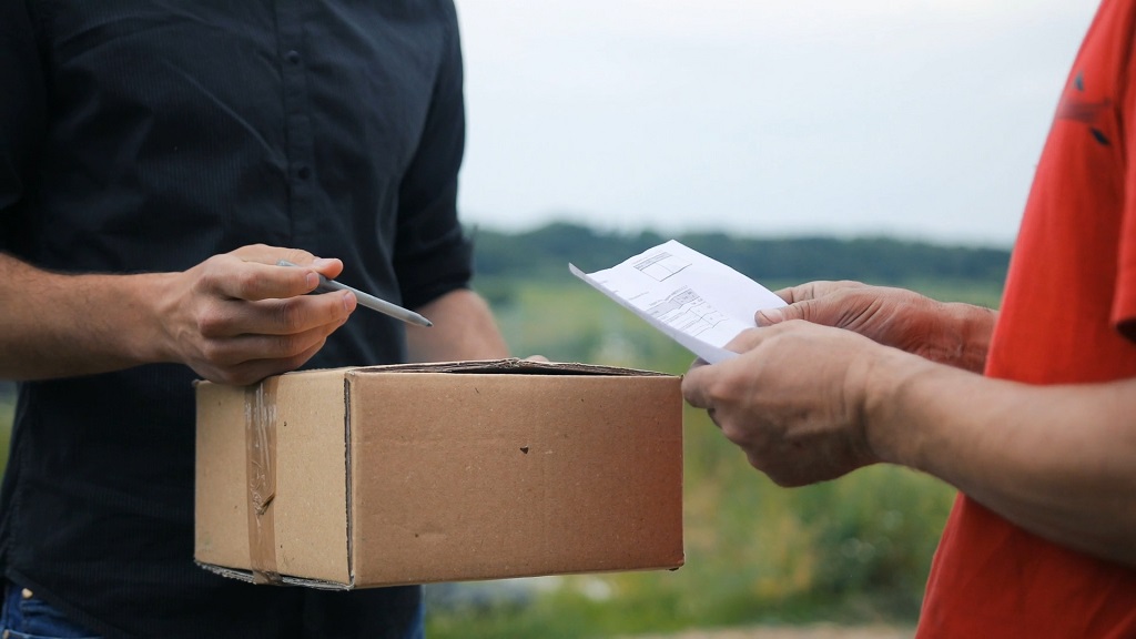 Kurir predaje paket i dokumentaciju kupcu na potpisivanje